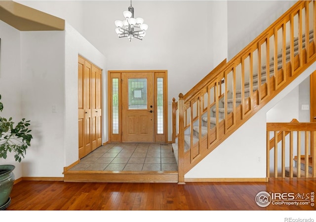 1502 Westfield Dr, Fort Collins, CO 80526 - entrance foyer featuring wood-type flooring, a towering ceiling, baseboards, a chandelier, and stairway