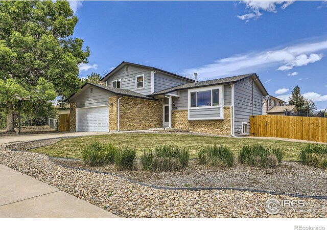 2447 E 100th Way, Thornton, CO 80229 - tri-level home with brick siding, a garage, and concrete driveway