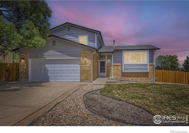 2447 E 100th Way, Thornton, CO 80229 - view of front of house with concrete driveway, a garage, and brick siding
