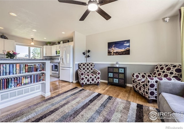 2447 E 100th Way, Thornton, CO 80229 - sitting room with light wood-style floors, a ceiling fan, recessed lighting, and baseboards