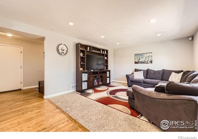 2447 E 100th Way, Thornton, CO 80229 - living room featuring recessed lighting, baseboards, and wood finished floors