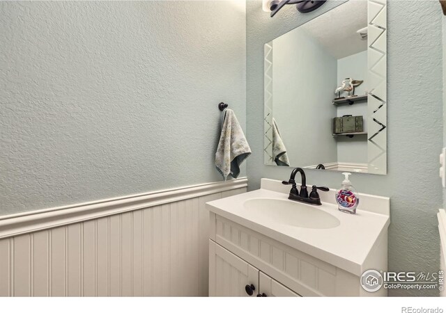2447 E 100th Way, Thornton, CO 80229 - bathroom featuring a textured wall and vanity