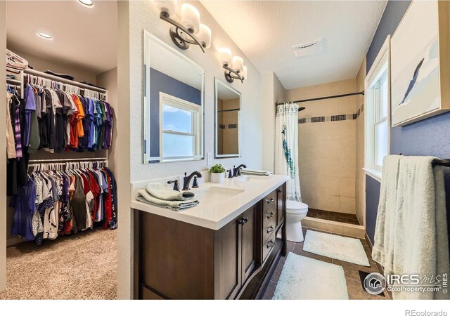 2447 E 100th Way, Thornton, CO 80229 - bathroom featuring toilet, vanity, tiled shower, a spacious closet, and recessed lighting