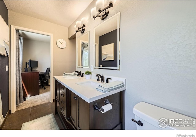 2447 E 100th Way, Thornton, CO 80229 - bathroom with tile patterned flooring, toilet, double vanity, and a textured wall