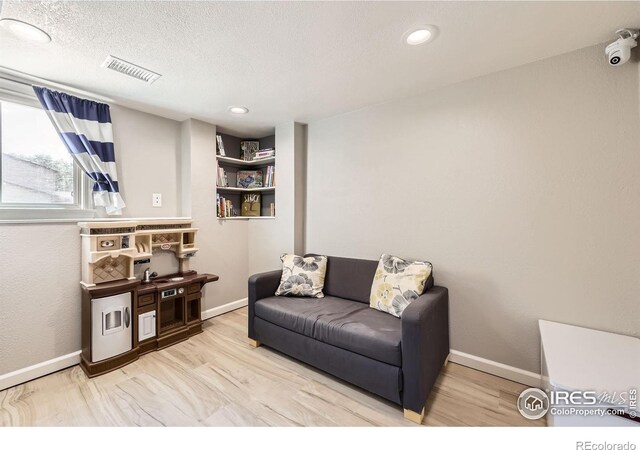 2447 E 100th Way, Thornton, CO 80229 - sitting room featuring baseboards, wood finished floors, a textured ceiling, and recessed lighting