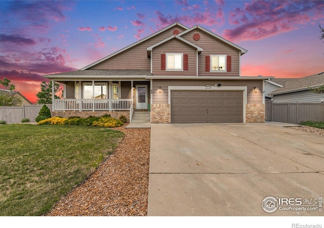 3328 Wild W Ln, Wellington, CO 80549 - view of front of house with a porch, a garage, driveway, and brick siding