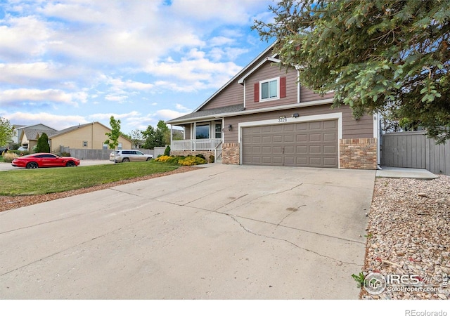 3328 Wild W Ln, Wellington, CO 80549 - view of front facade featuring a porch, driveway, an attached garage, and brick siding