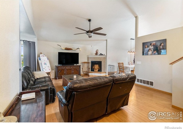 3328 Wild W Ln, Wellington, CO 80549 - living room with ceiling fan, light wood finished floors, vaulted ceiling, and a fireplace with raised hearth