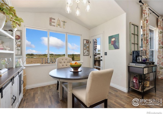 5869 Vinca Ave, Longmont, CO 80504 - dining room featuring lofted ceiling, dark wood-style flooring, a chandelier, and baseboards