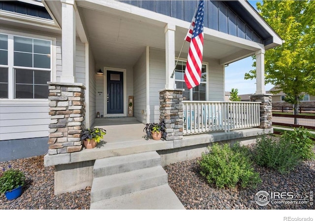 2150 Crop Row Dr, Windsor, CO 80550 - view of exterior entry with stone siding, covered porch, and board and batten siding