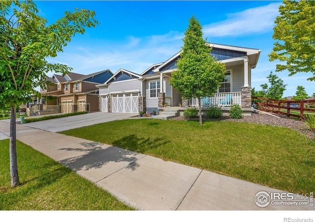 2150 Crop Row Dr, Windsor, CO 80550 - view of front of house featuring a garage, covered porch, driveway, and board and batten siding