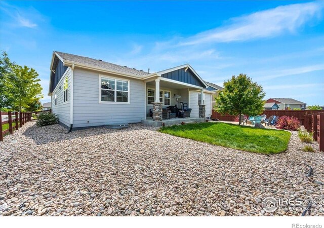 2150 Crop Row Dr, Windsor, CO 80550 - rear view of house featuring board and batten siding, a fenced backyard, and a patio area