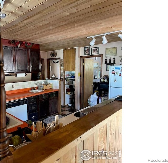 100 Santee Ct, Red Feather Lakes, CO 80545 - kitchen with white appliances, wooden ceiling, rail lighting, and decorative backsplash