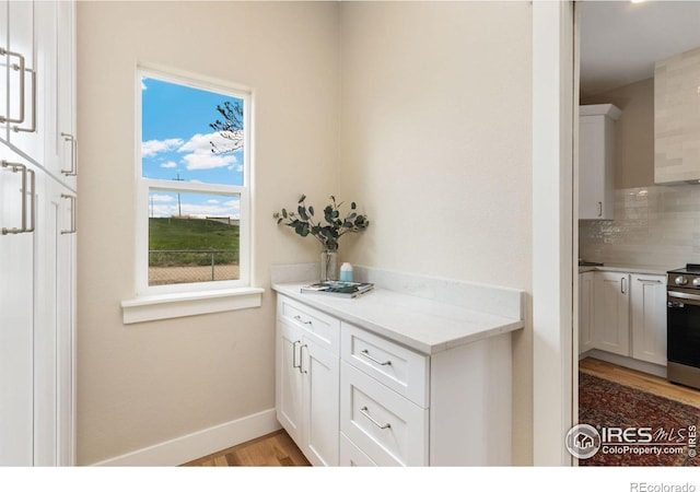 19810 County Road 1, Berthoud, CO 80513 - kitchen featuring light wood-style floors, white cabinetry, decorative backsplash, and light countertops