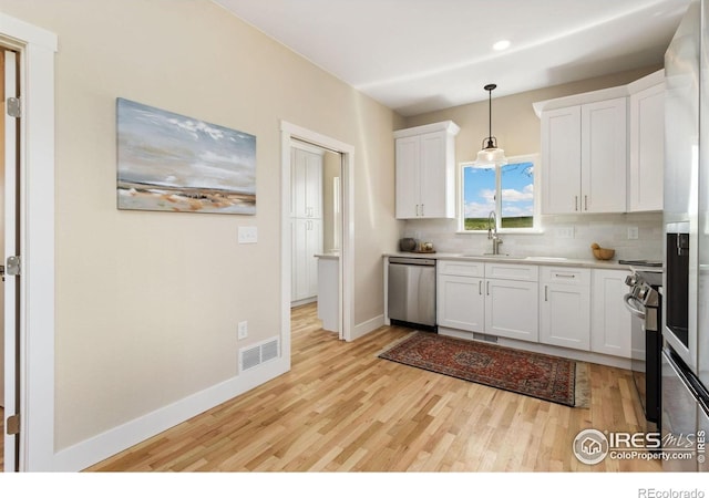 19810 County Road 1, Berthoud, CO 80513 - kitchen featuring appliances with stainless steel finishes, light wood finished floors, a sink, tasteful backsplash, and light countertops