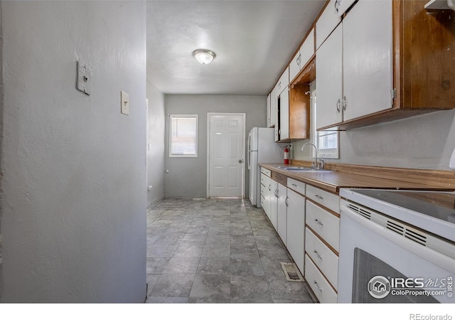 29 Marshall Pl, Longmont, CO 80504 - kitchen with a sink, white appliances, white cabinets, and baseboards