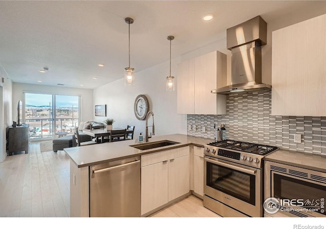 1616 S Broadway Unit 304, Denver, CO 80210 - kitchen featuring stainless steel appliances, island range hood, a sink, a peninsula, and open floor plan