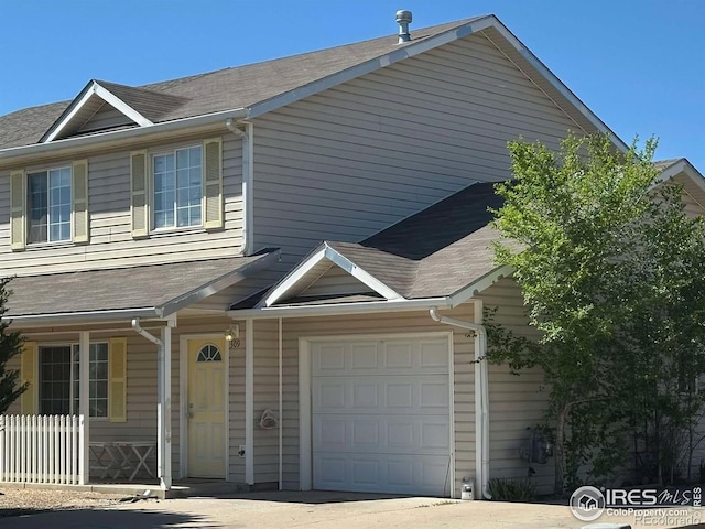 309 Ash Ct, Evans, CO 80620 - view of property featuring a garage, a shingled roof, and concrete driveway