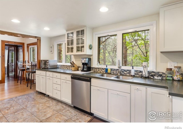 1031 W US Highway 34, Loveland, CO 80537 - kitchen featuring stainless steel appliances, a sink, dark countertops, decorative backsplash, and white cabinetry