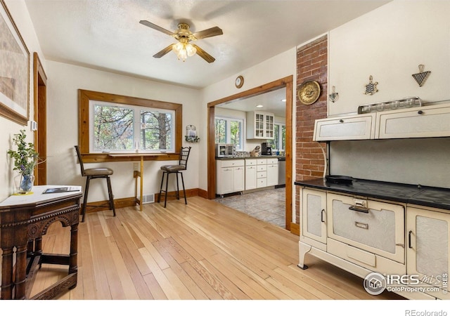 1031 W US Highway 34, Loveland, CO 80537 - kitchen with dark countertops, dishwasher, ceiling fan, light wood-style floors, and baseboards