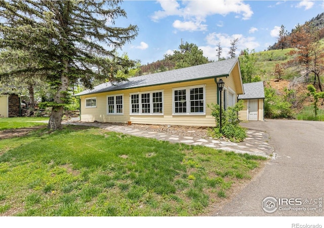 1031 W US Highway 34, Loveland, CO 80537 - back of house featuring a lawn, a shingled roof, and a garage
