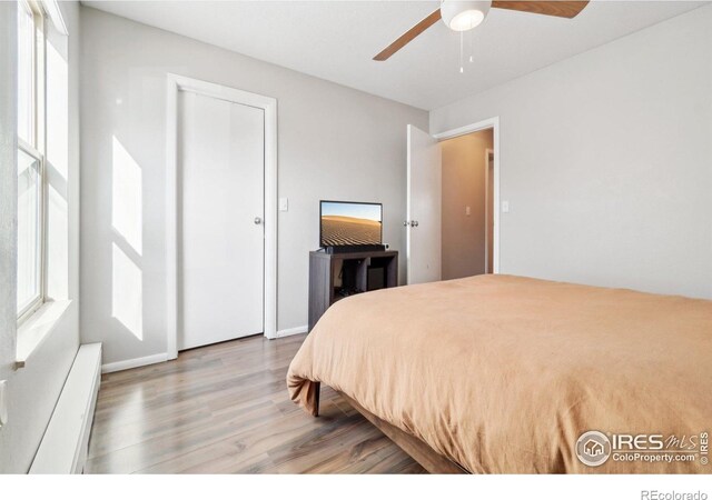 3431 Stover St Unit E-513, Fort Collins, CO 80525 - bedroom with wood finished floors, baseboard heating, and ceiling fan