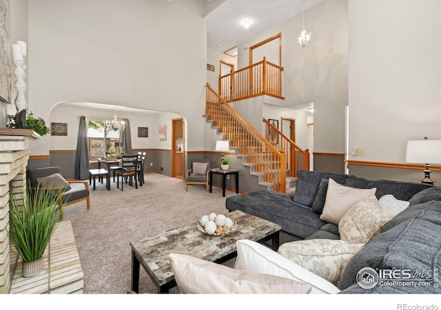 1202 Creekwood Ct, Windsor, CO 80550 - living room with arched walkways, a high ceiling, a chandelier, carpet flooring, and stairway