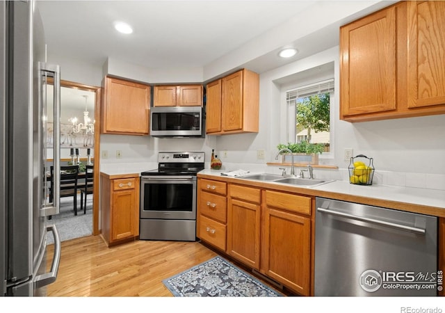 1202 Creekwood Ct, Windsor, CO 80550 - kitchen with appliances with stainless steel finishes, a sink, light wood-style flooring, light countertops, and recessed lighting