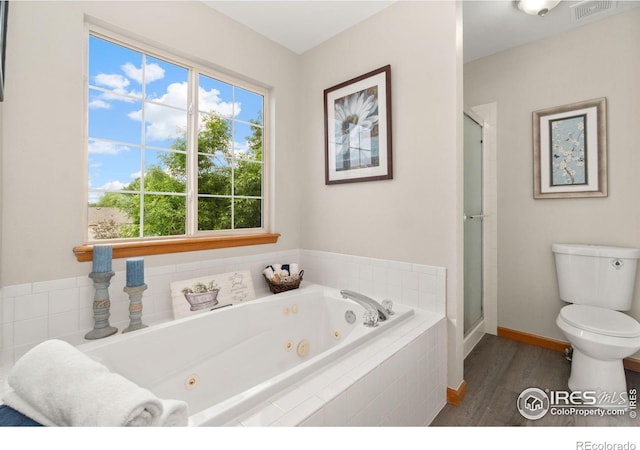 1202 Creekwood Ct, Windsor, CO 80550 - bathroom featuring toilet, a jetted tub, wood finished floors, a shower stall, and baseboards