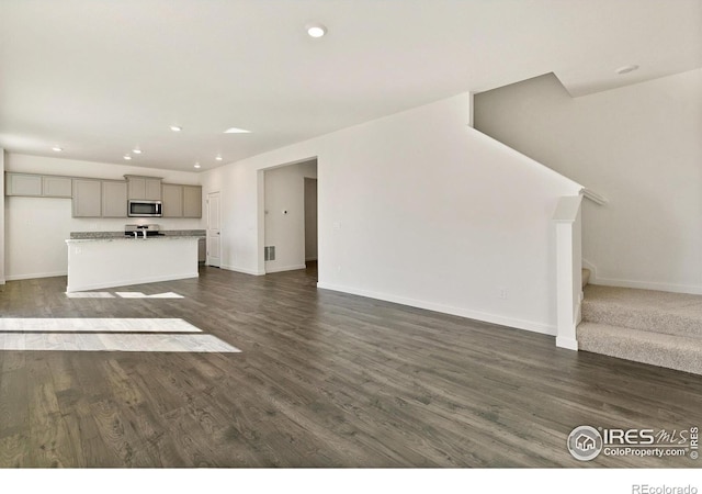 6300 Globeflower St, Wellington, CO 80549 - unfurnished living room with baseboards, stairs, recessed lighting, and dark wood-style floors