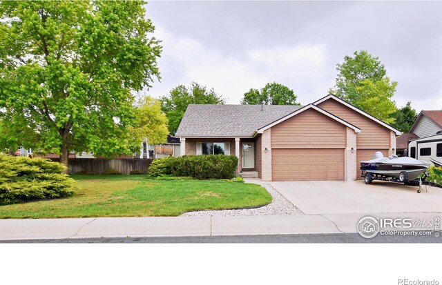 1131 Sandra Dr, Johnstown, CO 80534 - view of front facade with a garage, brick siding, concrete driveway, and roof with shingles