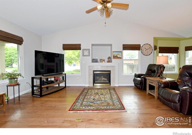 1131 Sandra Dr, Johnstown, CO 80534 - living room featuring vaulted ceiling, hardwood / wood-style flooring, plenty of natural light, a tile fireplace, and ceiling fan