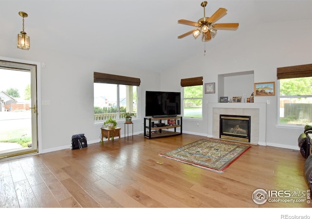 1131 Sandra Dr, Johnstown, CO 80534 - living area with wood finished floors, ceiling fan, a tiled fireplace, high vaulted ceiling, and baseboards