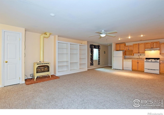 1131 Sandra Dr, Johnstown, CO 80534 - unfurnished living room with a wood stove, light colored carpet, a ceiling fan, heating unit, and a sink