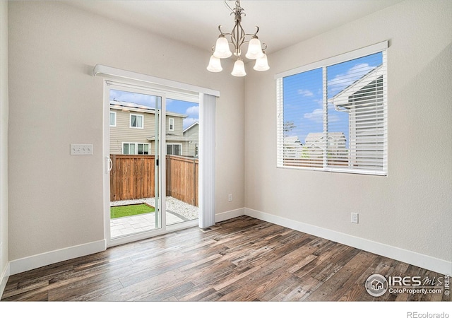 1211 104th Ave, Greeley, CO 80634 - spare room with a chandelier, wood finished floors, and baseboards