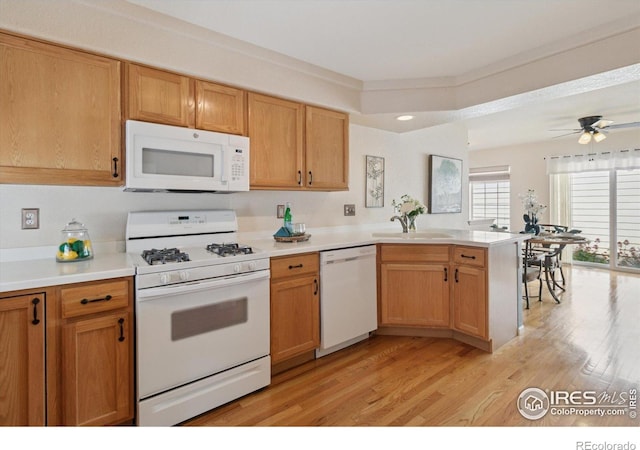 4725 Spyglass Dr, Broomfield, CO 80023 - kitchen with white appliances, a sink, a peninsula, light wood-style flooring, and light countertops