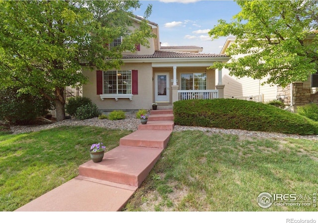 4725 Spyglass Dr, Broomfield, CO 80023 - view of front of home with covered porch, a front lawn, a tile roof, and stucco siding