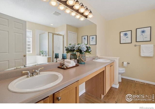 4725 Spyglass Dr, Broomfield, CO 80023 - full bathroom featuring double vanity, a stall shower, toilet, wood finished floors, and baseboards