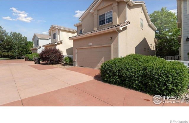 4725 Spyglass Dr, Broomfield, CO 80023 - view of front of house with a garage, stucco siding, and driveway