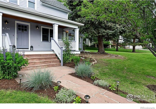 3561 4th St, Boulder, CO 80304 - doorway to property with covered porch, a lawn, and roof with shingles
