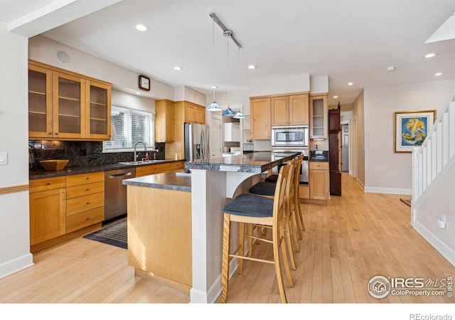 3561 4th St, Boulder, CO 80304 - kitchen featuring stainless steel appliances, dark countertops, light wood-style flooring, a kitchen breakfast bar, and recessed lighting