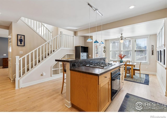 3561 4th St, Boulder, CO 80304 - kitchen with oven, stainless steel gas cooktop, light wood-style flooring, dark countertops, and recessed lighting
