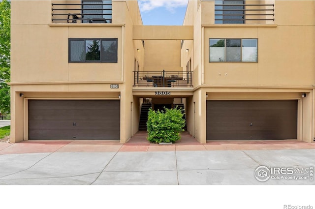 3805 Northbrook Dr Unit A, Boulder, CO 80304 - view of front of house with an attached garage, a balcony, stucco siding, and driveway
