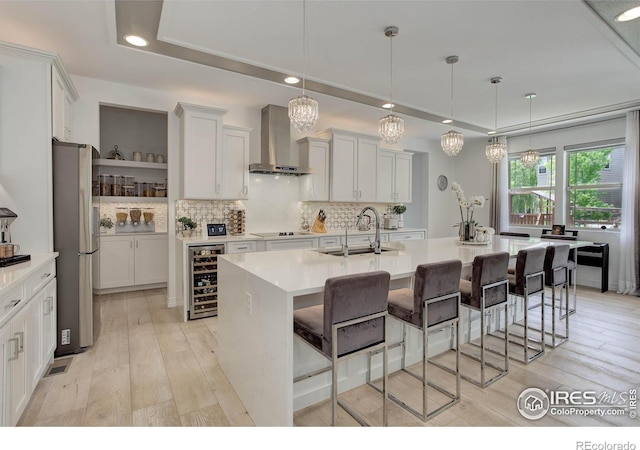 9527 Loveland Way, Arvada, CO 80007 - kitchen with wall chimney exhaust hood, beverage cooler, a sink, freestanding refrigerator, and backsplash