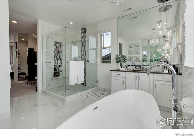 9527 Loveland Way, Arvada, CO 80007 - bathroom with a freestanding tub, a marble finish shower, a chandelier, vanity, and recessed lighting