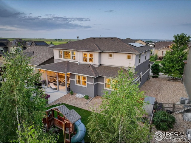 9527 Loveland Way, Arvada, CO 80007 - back of house featuring stucco siding, a shingled roof, a patio area, and a residential view