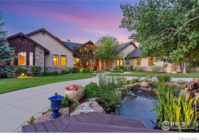 8236 County Road 74, Windsor, CO 80550 - view of front of home with stucco siding, stone siding, and a lawn