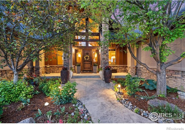 8236 County Road 74, Windsor, CO 80550 - property entrance with stone siding, covered porch, and stucco siding