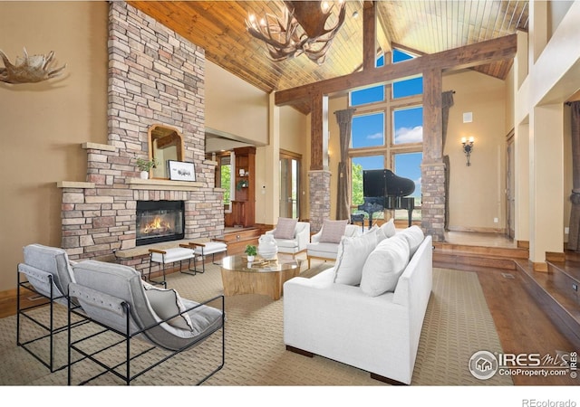 8236 County Road 74, Windsor, CO 80550 - living room featuring high vaulted ceiling, a fireplace, a chandelier, wood finished floors, and wooden ceiling with exposed beams