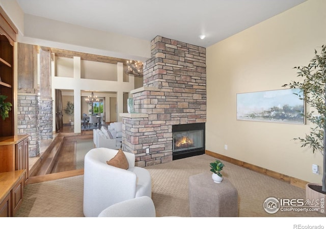 8236 County Road 74, Windsor, CO 80550 - living area featuring a chandelier, a stone fireplace, carpet, and baseboards